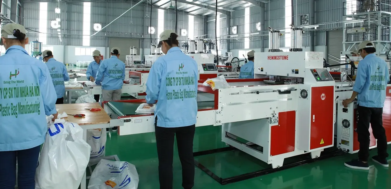 Factory workers operating advanced plastic bag manufacturing machines in Vietnam production facility