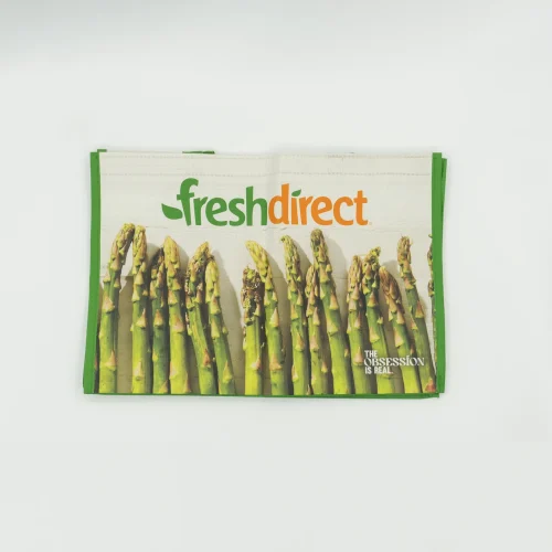 FreshDirect bag with green sides and a row of asparagus; brand name appears at top center.